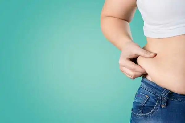 Image of woman pinching her love handles to show weight gain Southsea